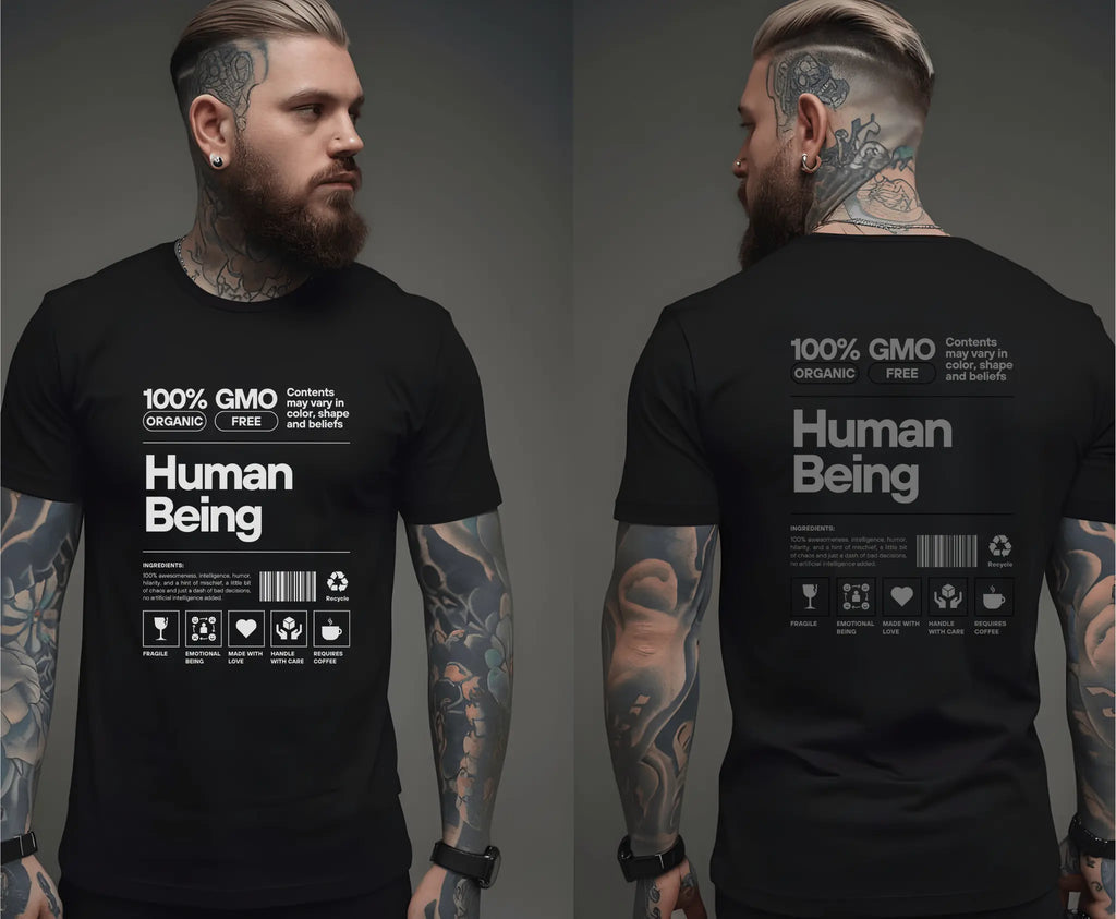 Mann mit Bart und Tattoos trägt schwarzes Bio-T-Shirt „Human Being“-Design mit weißem Druck.