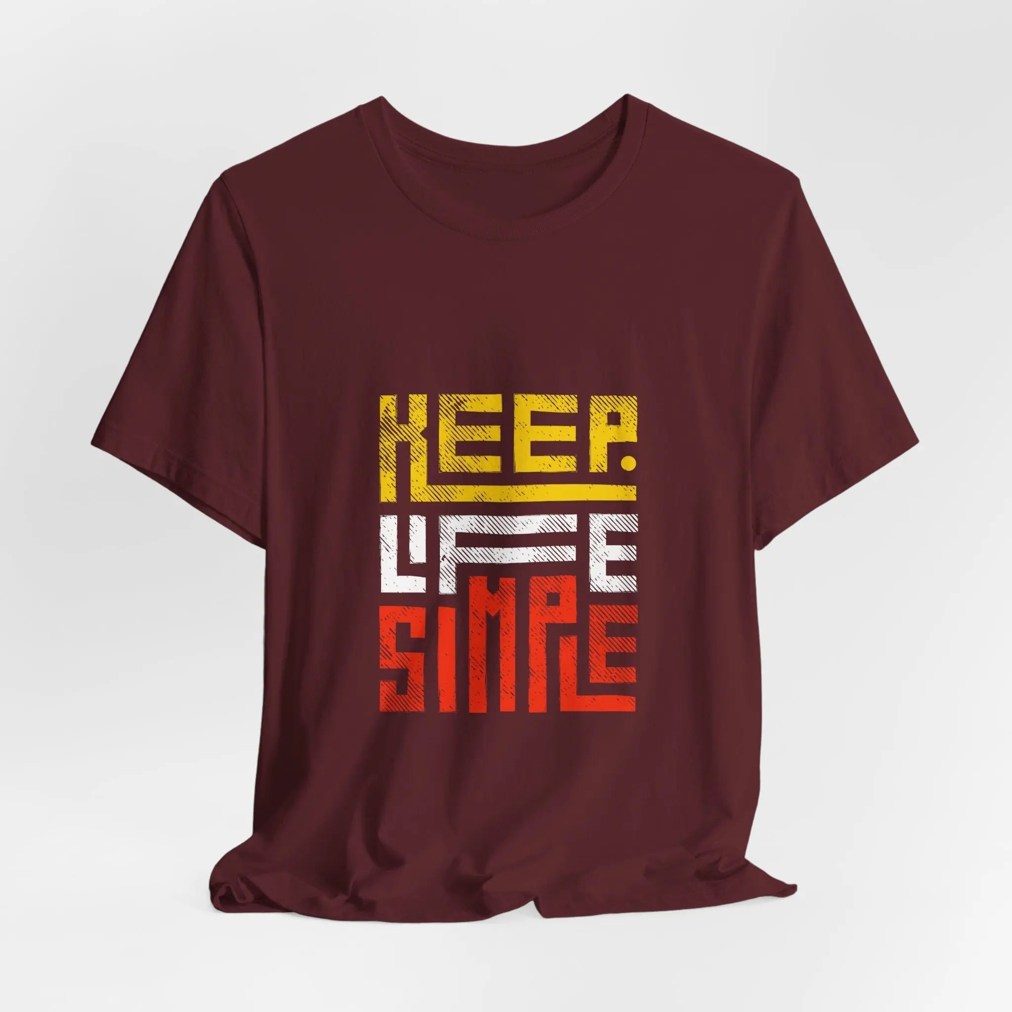 Mann trägt burgunderrotes T-Shirt mit „Keep Life Simple“-Design.