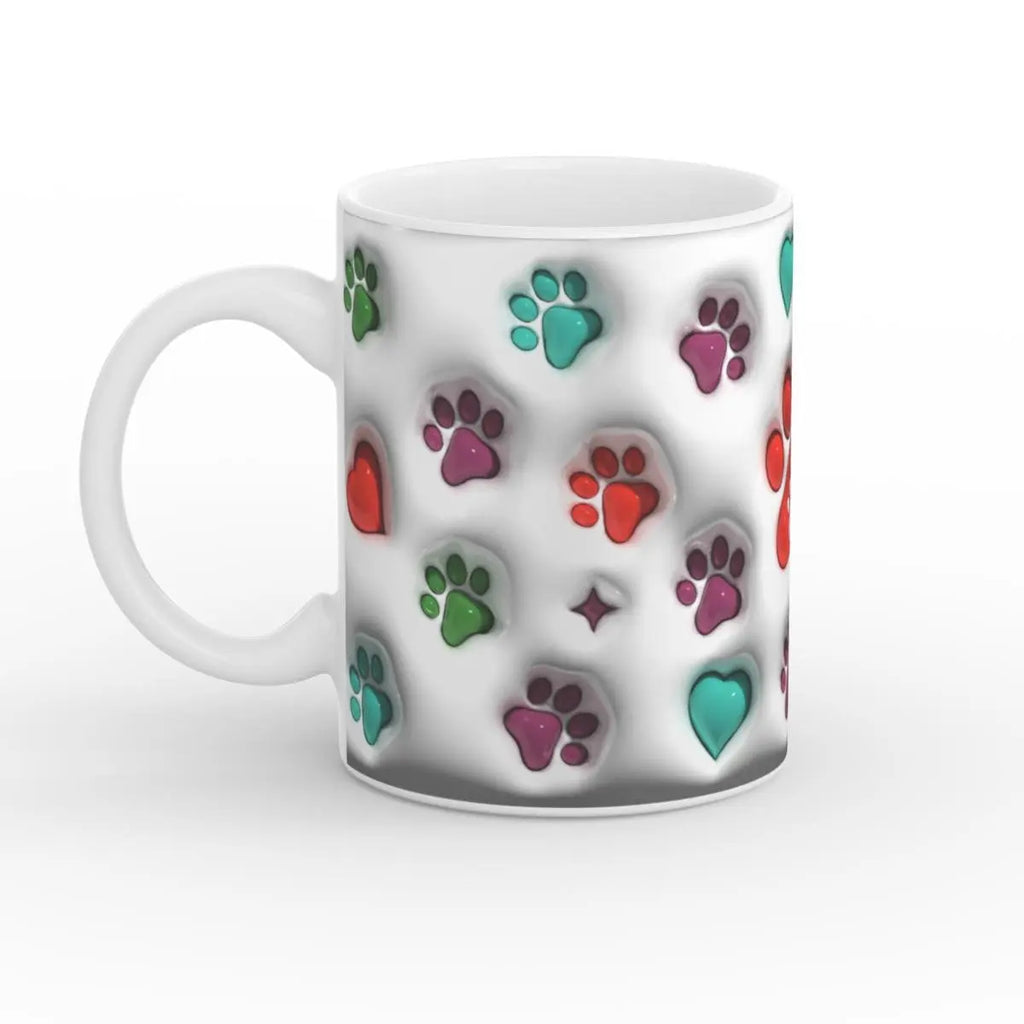 Weiße Keramiktasse mit bunten Pfotenabdrücken und Herzen, seitliche Ansicht mit Henkel auf der linken Seite.